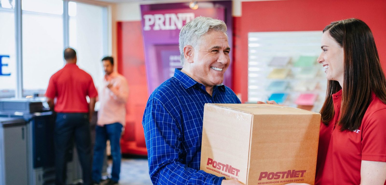 Image of a customer handing off box at a PostNet location.