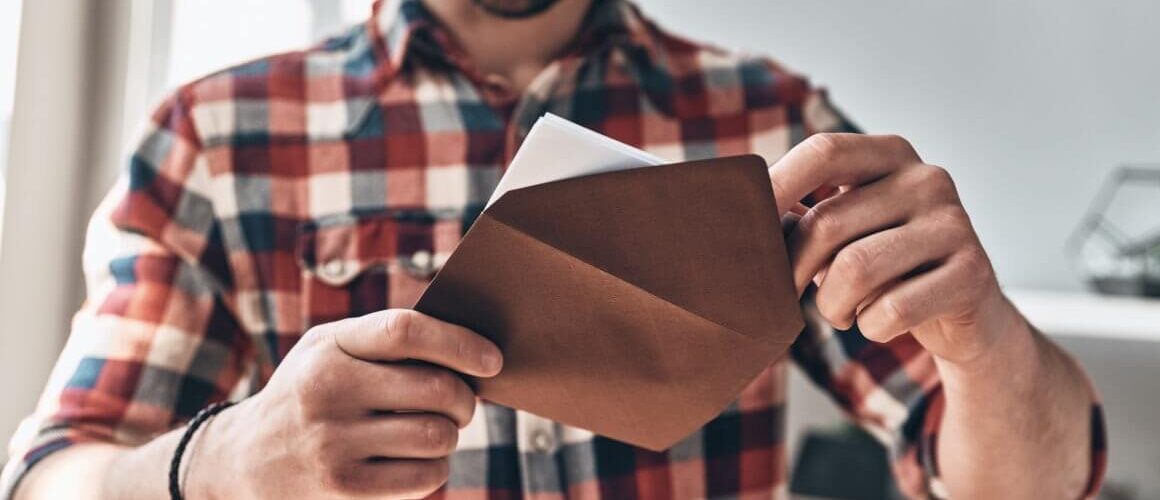 Person opening brown envelope. 