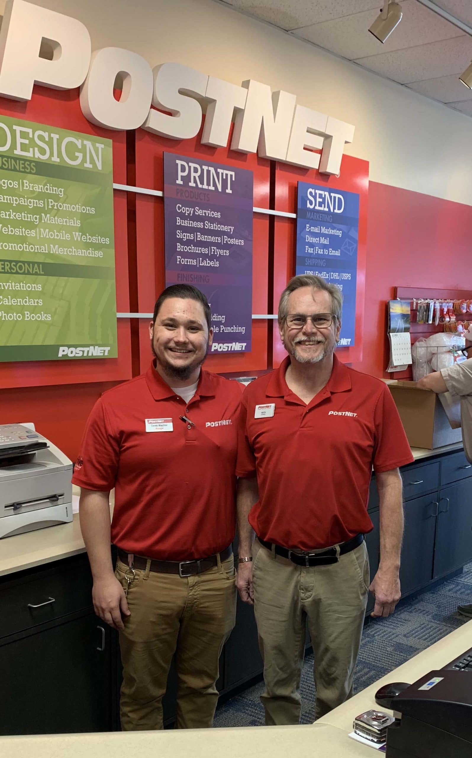 Two PostNet employees smiling in their uniform