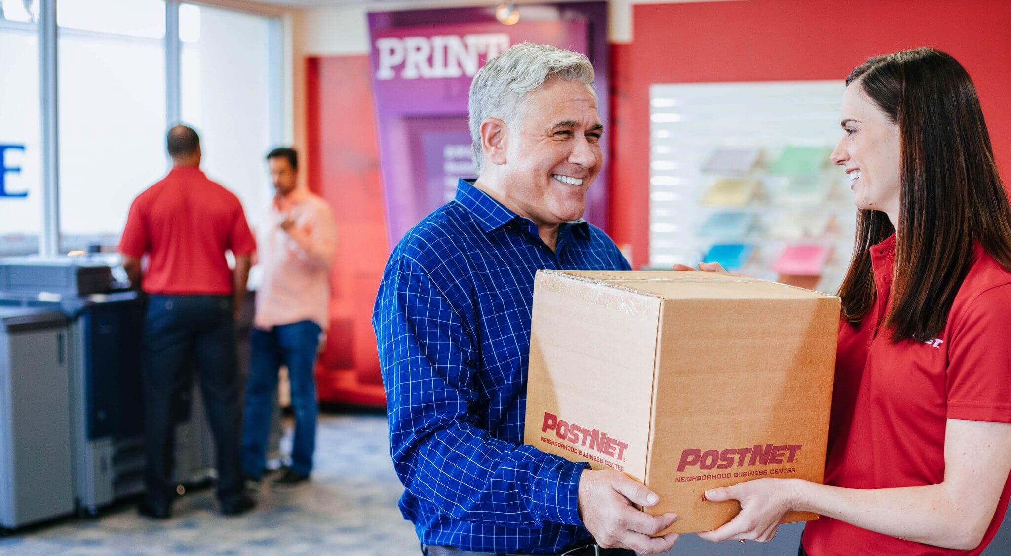 Image of a customer handing off box at a PostNet location.